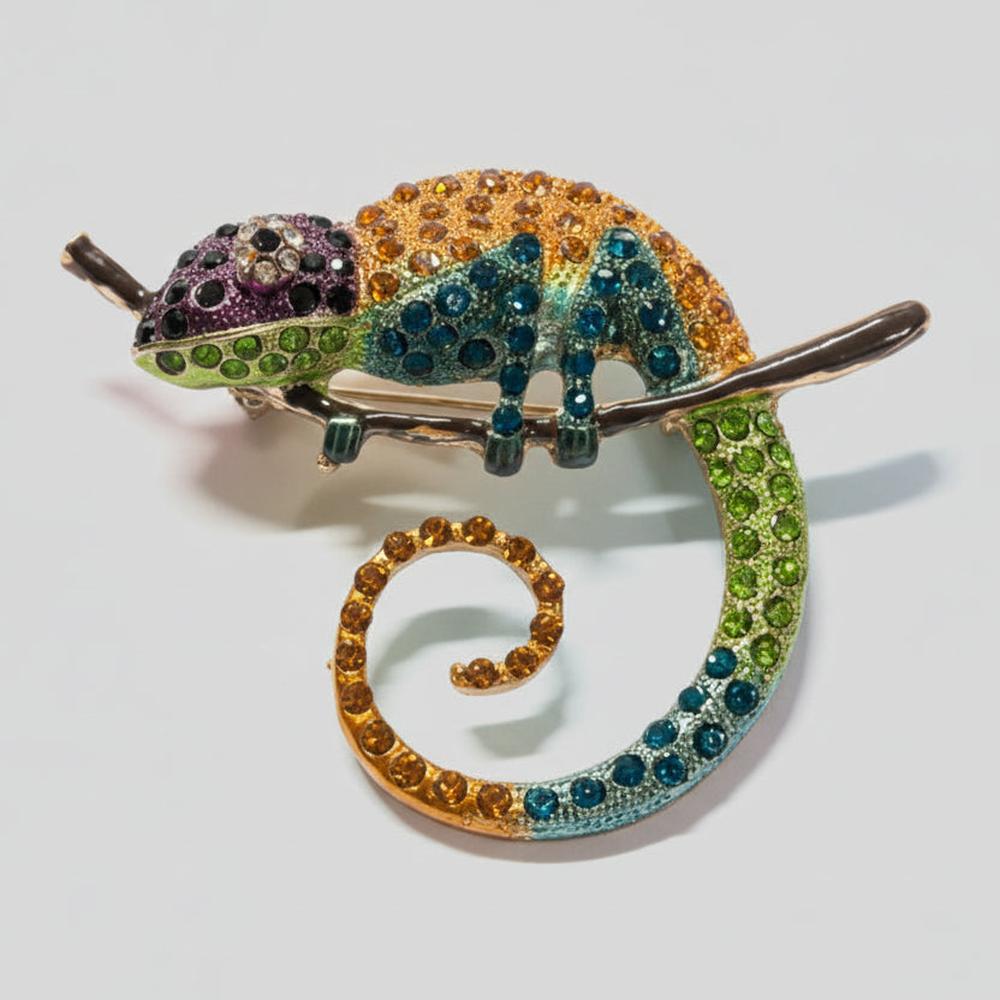 Colorful rhinestone chameleon-shaped brooch on a light gray background