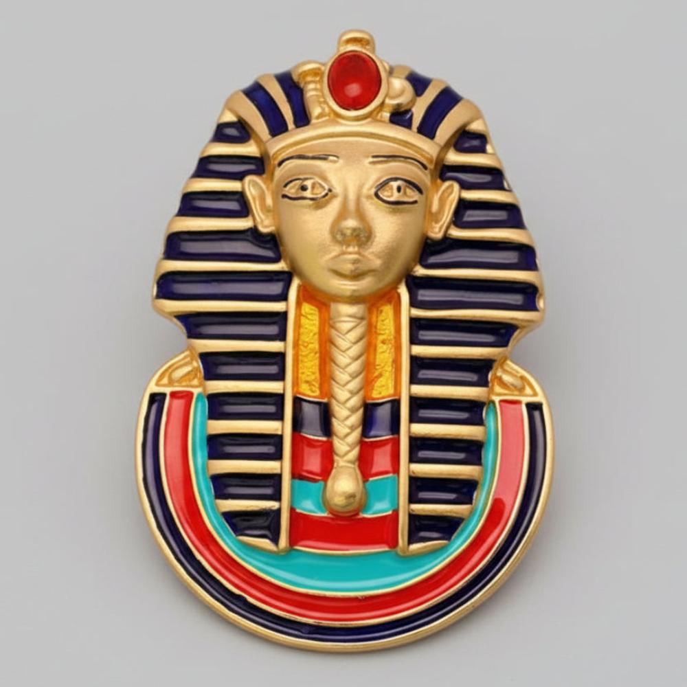 Decorative brooch with Egyptian sphinx design on a light gray background