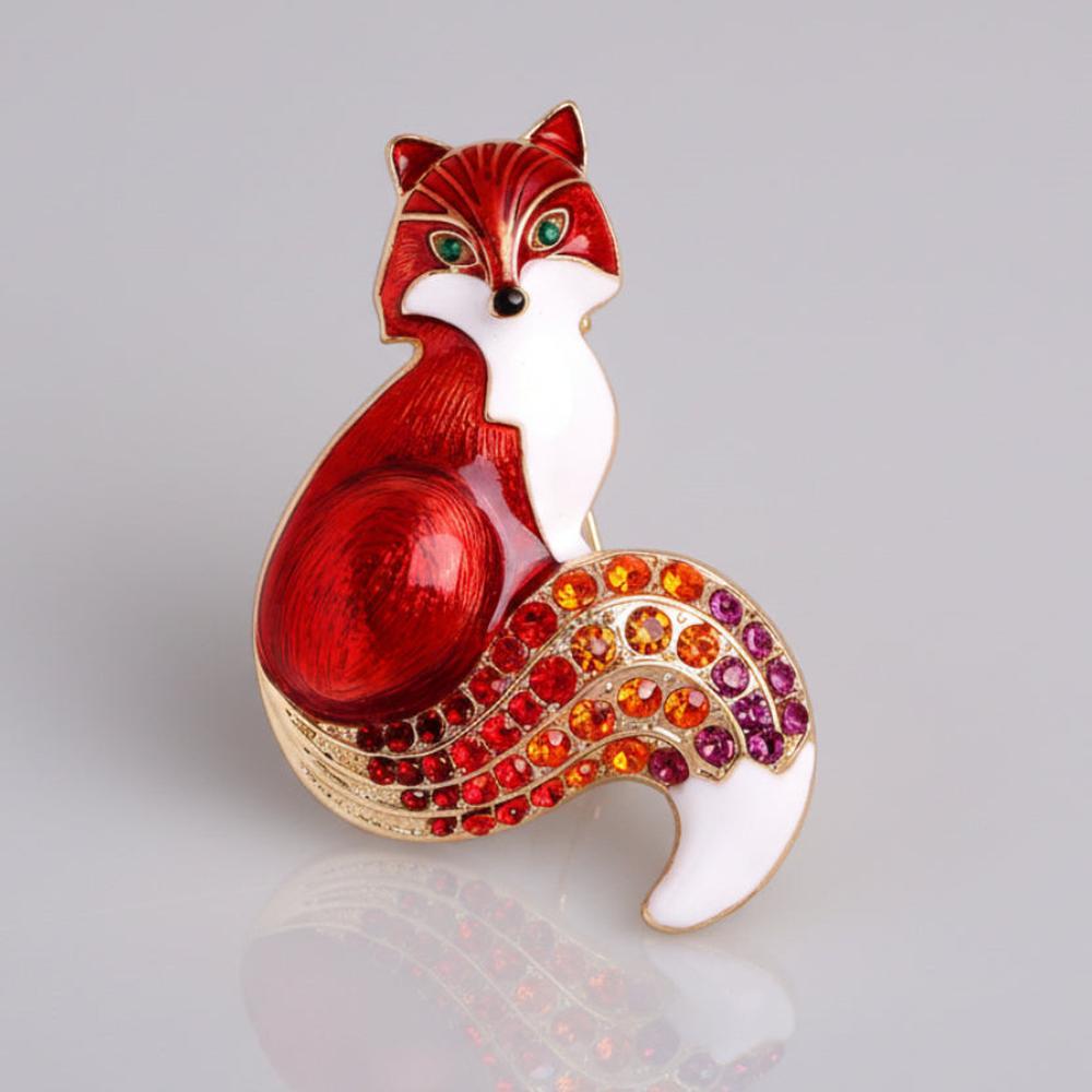 Red fox-shaped brooch with colorful rhinestone tail on a light gray background