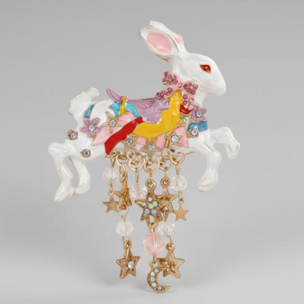 Colorful royal rabbit brooch with star and moon charms on a light gray background